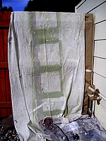 Wood fence covered with drop cloth and paper.