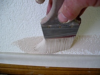 Using a brush to cut-in the wall to the base.