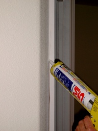 Using siliconized acrylic caulk on a door frame.