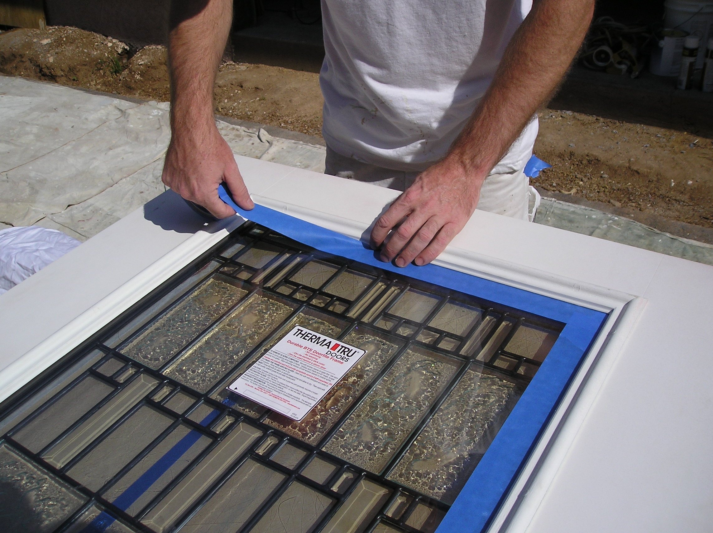 Masking a window before spraying a steel door.